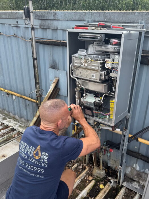 Gas Safe engineer from Senior Heating Services diagnosing a fault on an external boiler